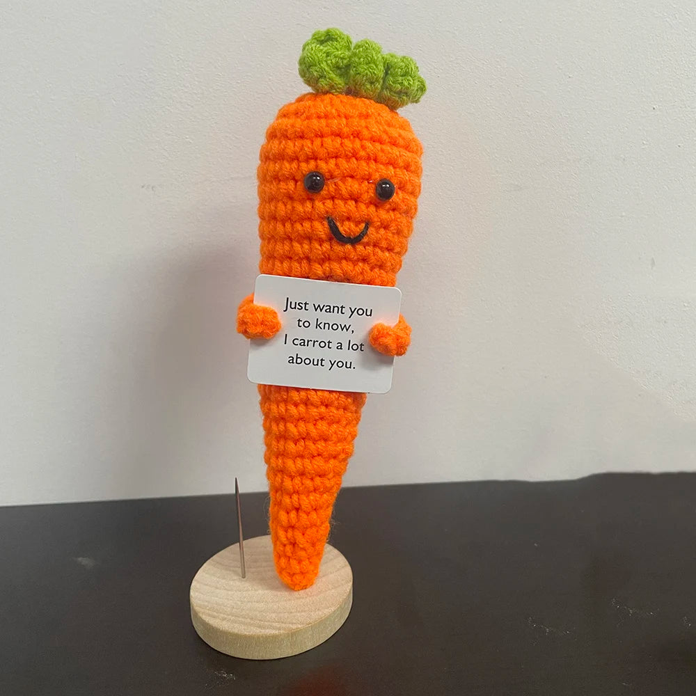 Handmade crochet carrot plush doll with smiling face, holding a sign that says "Just want you to know, I carrot a lot about you.